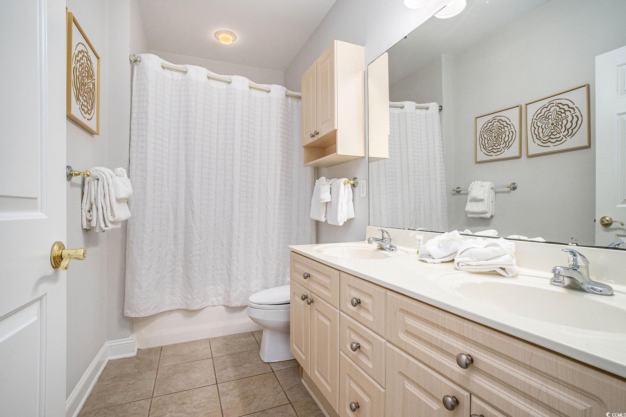 4894 Luster Leaf Circle, Unit 303 Myrtle Beach, SC 29577 - Photo 21 of 31 Full bath with light tile patterned floors, double vanity, and shower / tub combo with curtain