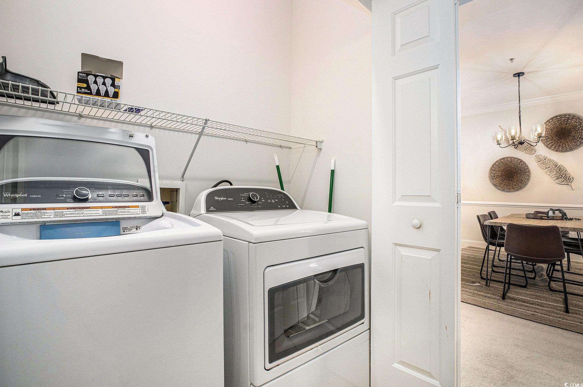 4894 Luster Leaf Circle, Unit 303 Myrtle Beach, SC 29577 - Photo 23 of 31 Laundry room with a chandelier and washing machine and clothes dryer