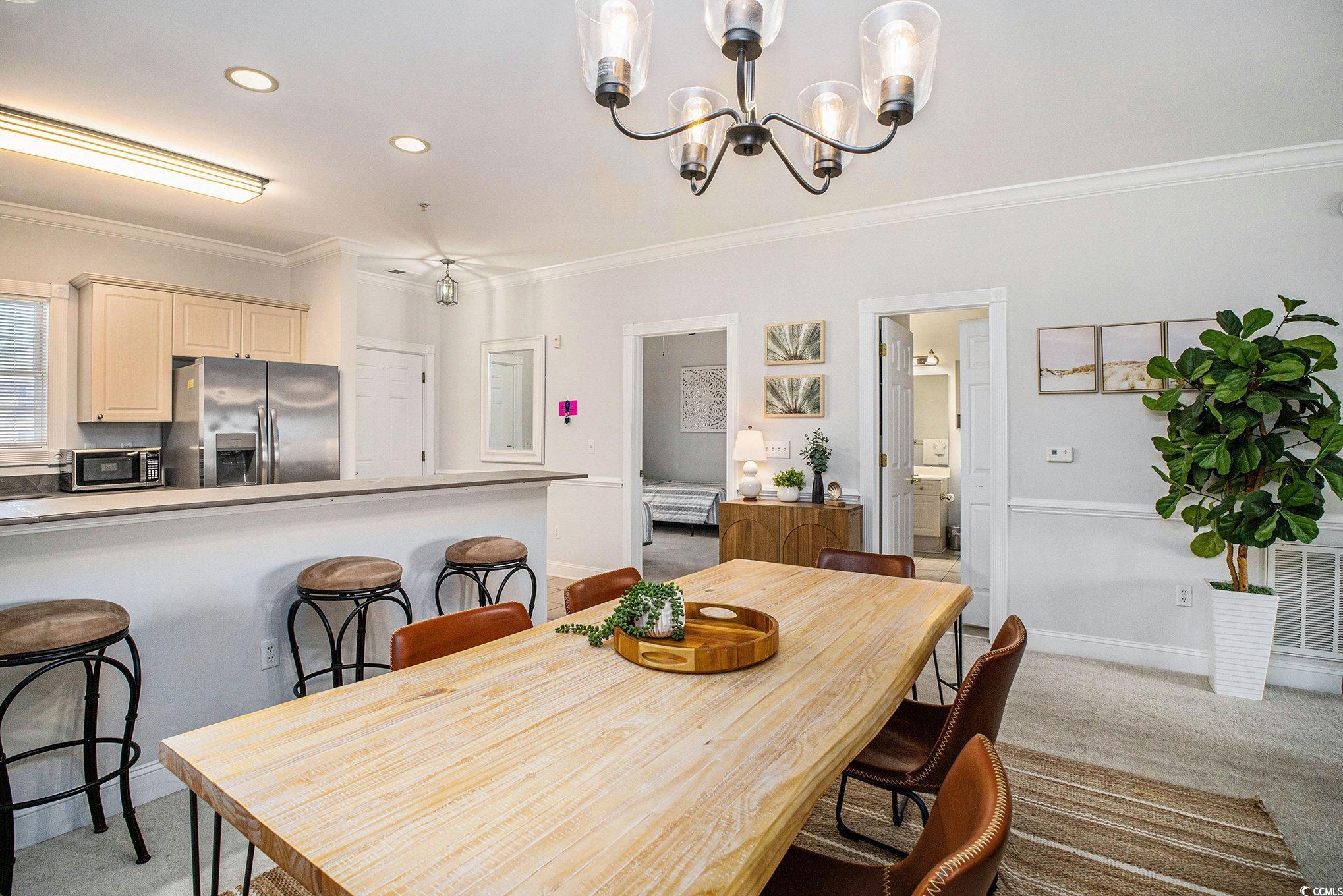 4894 Luster Leaf Circle, Unit 303 Myrtle Beach, SC 29577 - Photo 8 of 31 Dining space with ornamental molding, light carpet, a chandelier, and recessed lighting