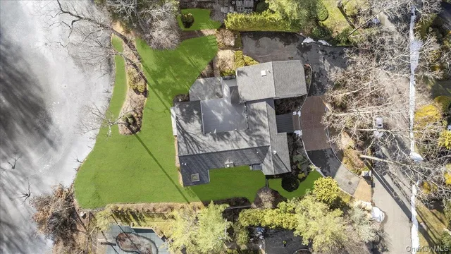 a aerial view of a house with a yard and large tree
