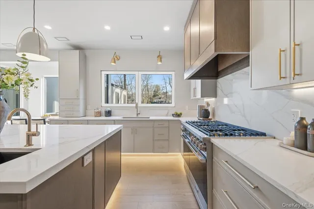 a kitchen with stainless steel appliances granite countertop a sink a stove and a wooden floors