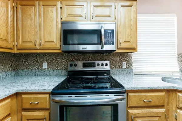 a stove top oven sitting inside of a kitchen