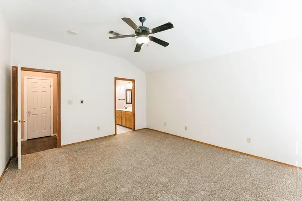 an empty room with ceiling fan and window