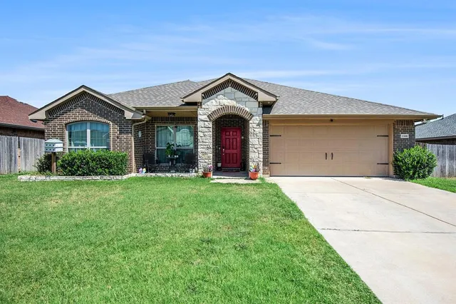 a view of a house with yard and garage