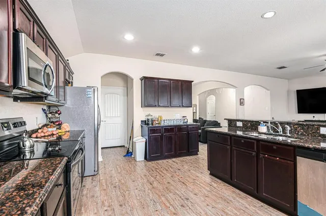 a kitchen with stainless steel appliances granite countertop a stove and a sink