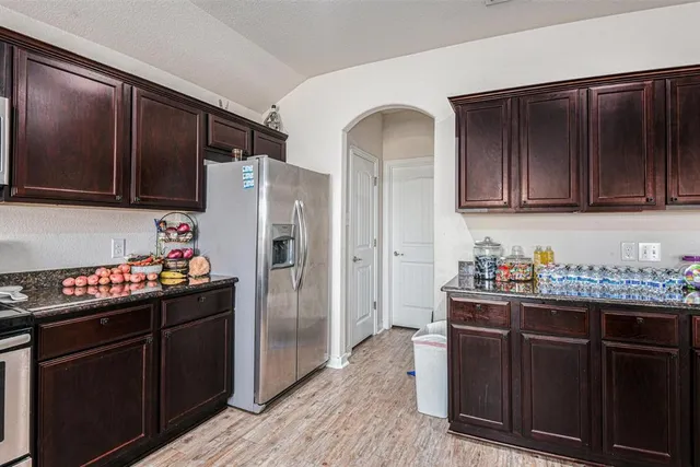 a kitchen with a refrigerator and a stove top oven