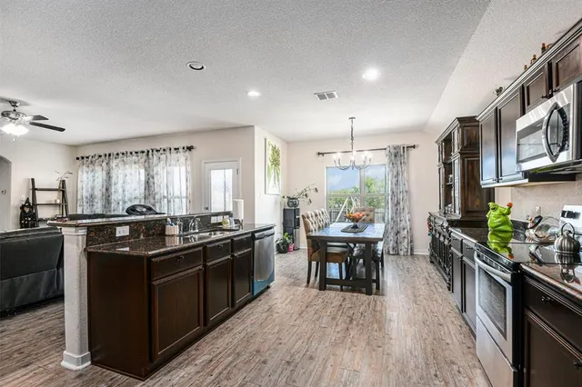 a kitchen with stainless steel appliances granite countertop sink stove top oven and cabinets