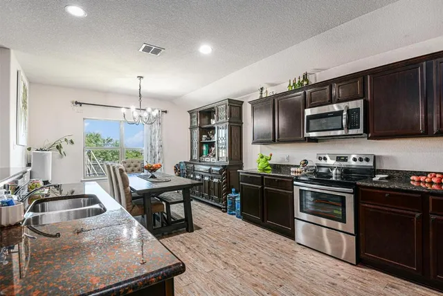 a kitchen with lots of counter top space a sink appliances and cabinets