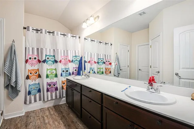 a bathroom with a sink double vanity mirror and shower