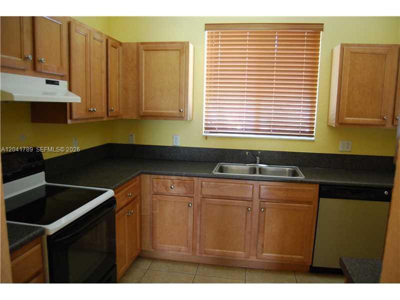 12080 Southwest 268th Street, Unit 24 Homestead, FL 33032 - Photo 6 of 29 a kitchen that has a sink and cabinets