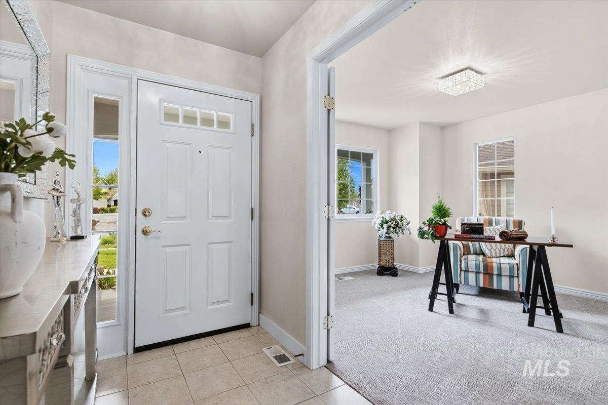 725 North Eagle Road Eagle, ID 83616 - Photo 20 of 45 Entryway featuring a white paneled door with transom window and side panel, tile flooring, and a decorative console table