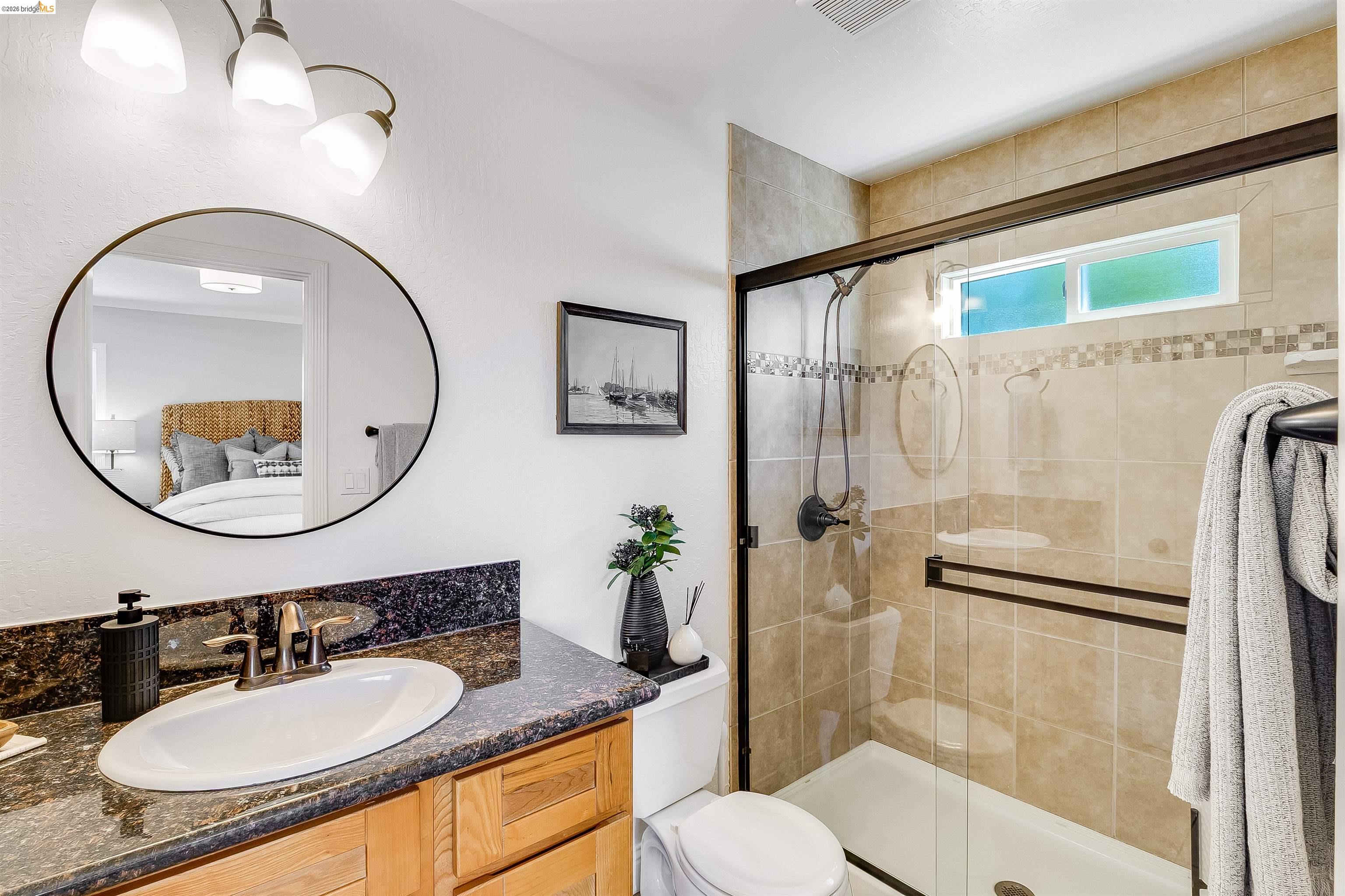 346 Valley View Road Pleasant Hill, CA 94523 - Photo 27 of 57 Bathroom featuring a glass-enclosed shower with tile surround, a built-in shower niche, and an upper transom window
