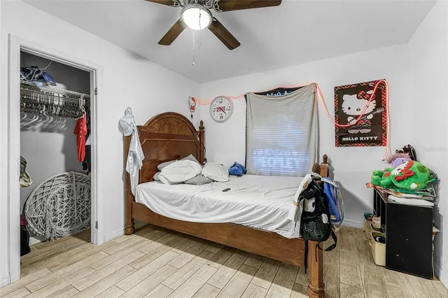 a bed sitting in a bedroom next to a window and a chandelier