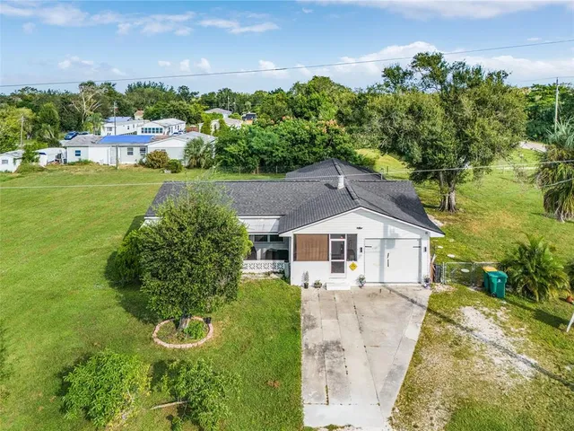 an aerial view of a house with a garden and lake view
