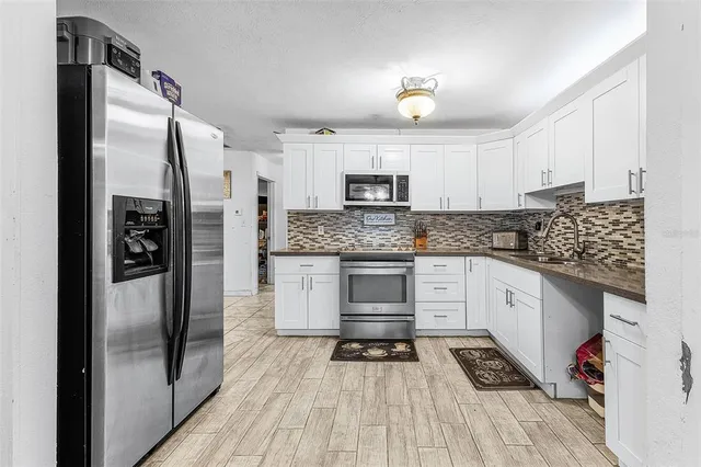 a kitchen with granite countertop a refrigerator stove and sink