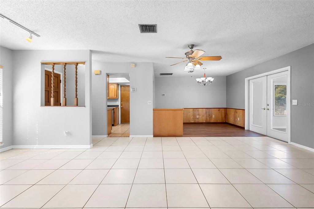 286 Valencia Road DeBary, FL 32713 - Photo 7 of 38 a view of an empty room with a chandelier fan and a window