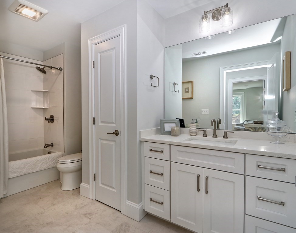 73 Rowell Road, Unit 73 Middleton , MA 01923 - Photo 34 of 40 a bathroom with a double vanity sink toilet mirror and windows