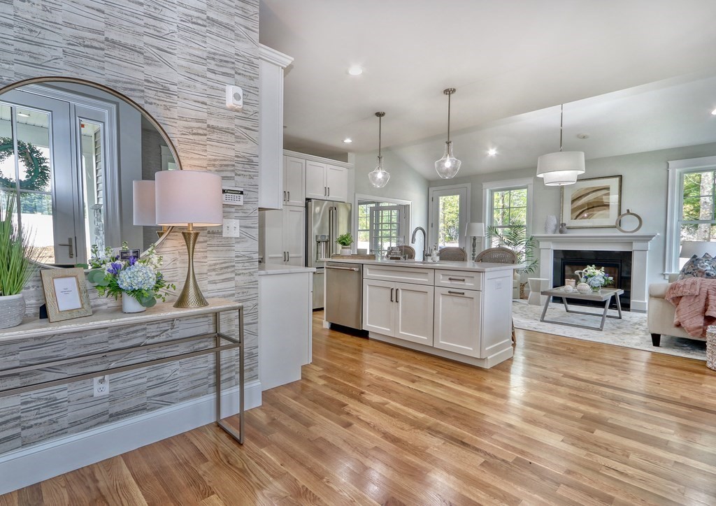 73 Rowell Road, Unit 73 Middleton , MA 01923 - Photo 6 of 40 a large white kitchen with kitchen island a stove a sink cabinets and a wooden floor