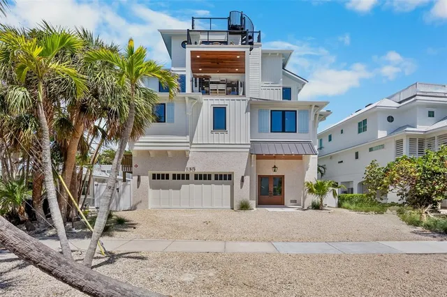 a view of a white building among the street with palm trees