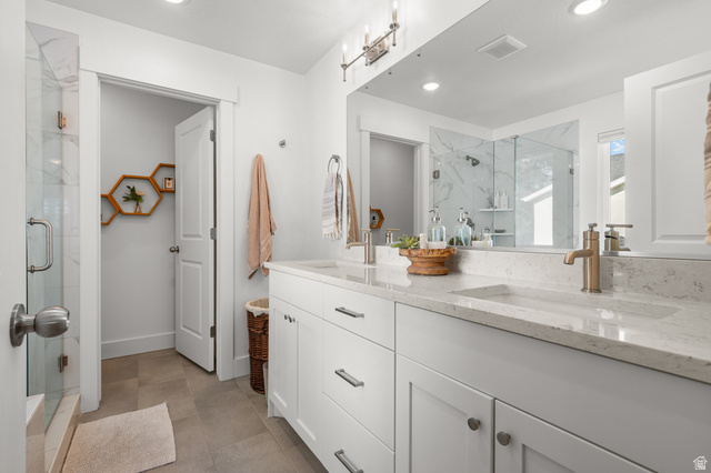 2706 West Maple Street, Unit 285 Mapleton, UT 84664 - Photo 19 of 36 Double vanity with integrated sinks, light-toned countertops, and dual bronze-finish faucets