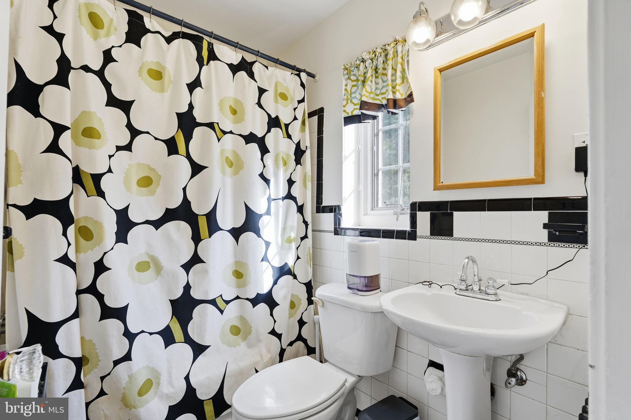8209 Meadowbrook Lane Chevy Chase, MD 20815 - Photo 15 of 24 a bathroom with a sink toilet mirror and shower