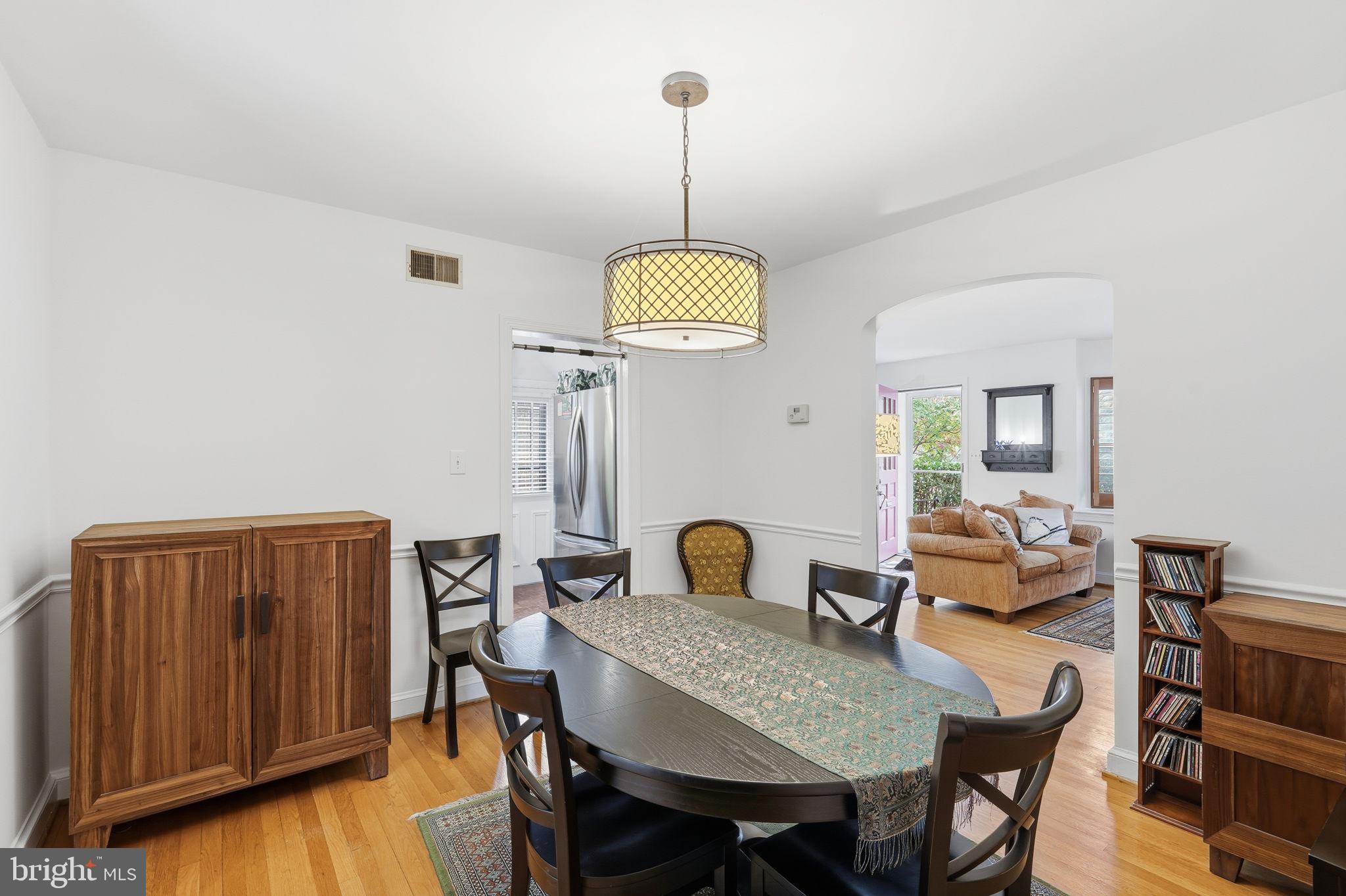 8209 Meadowbrook Lane Chevy Chase, MD 20815 - Photo 5 of 24 a dining room with furniture a chandelier and wooden floor