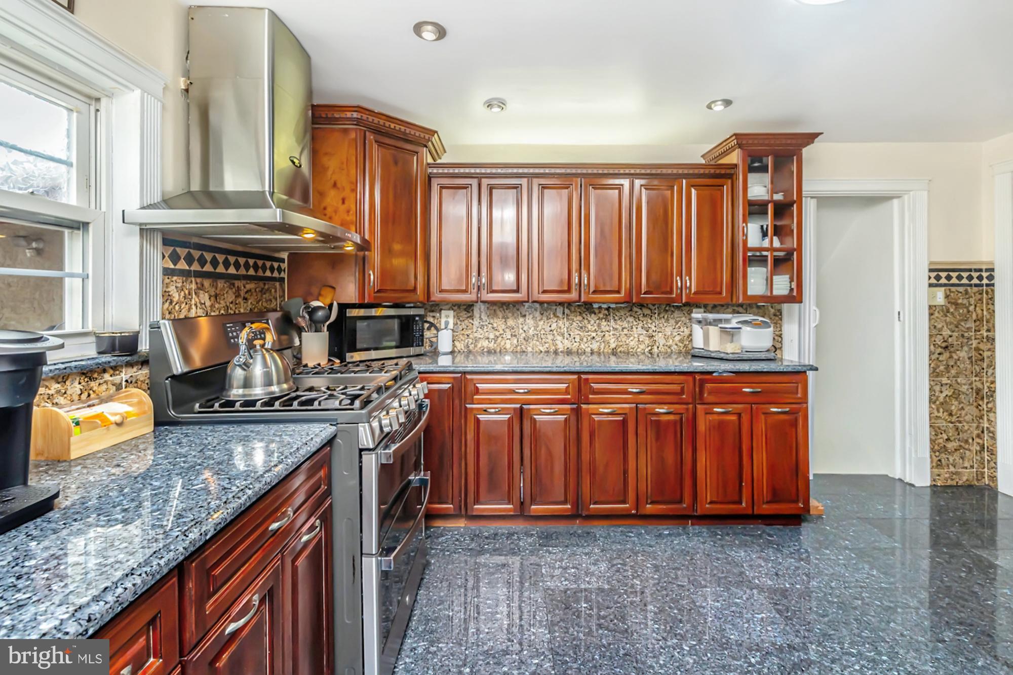 320 Prospect Road Springfield, PA 19064 - Photo 16 of 78 a kitchen with stainless steel appliances granite countertop a stove a sink and a microwave