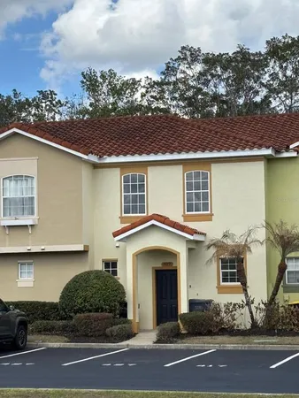 a view of a white house with large windows and a yard