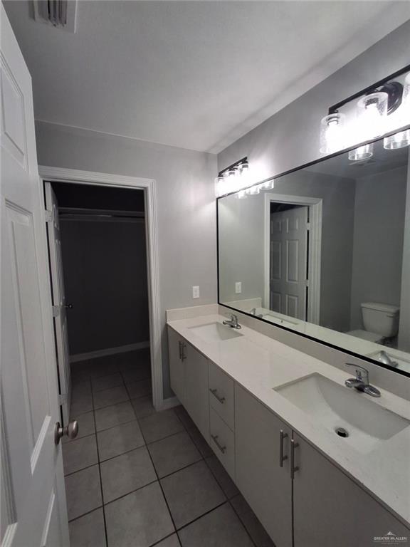 2104 Multi National, Unit C Harlingen, TX 78550 - Photo 13 of 14 a bathroom with a double vanity sink and mirror