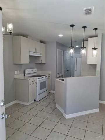 a large kitchen with white cabinets and stainless steel appliances