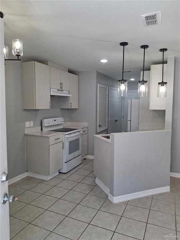 2104 Multi National, Unit C Harlingen, TX 78550 - Photo 5 of 14 a large kitchen with white cabinets and stainless steel appliances