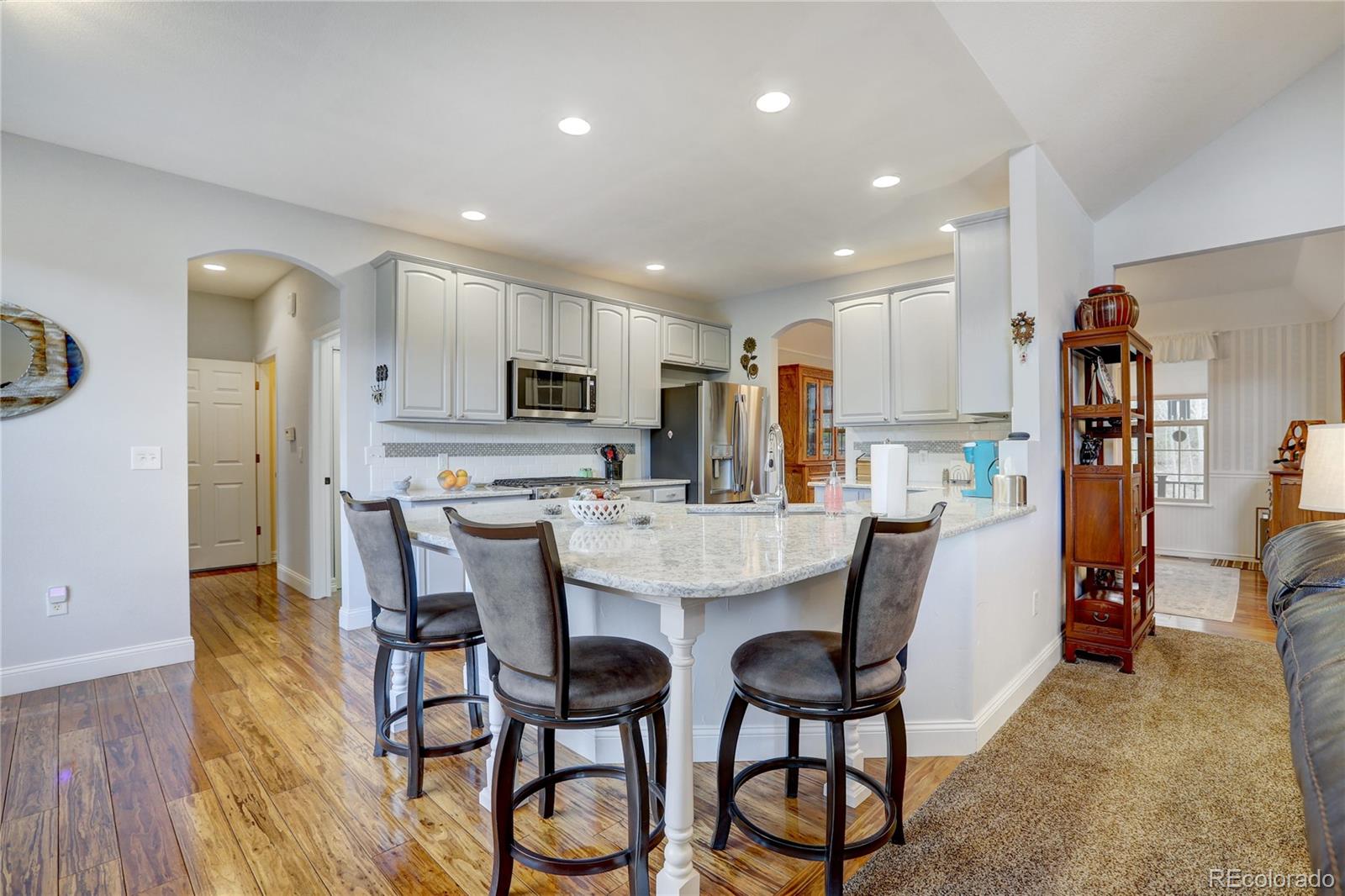 634 Foxtail Circle Black Hawk, CO 80422 - Photo 11 of 40 a kitchen with stainless steel appliances kitchen island granite countertop a dining table chairs refrigerator and sink