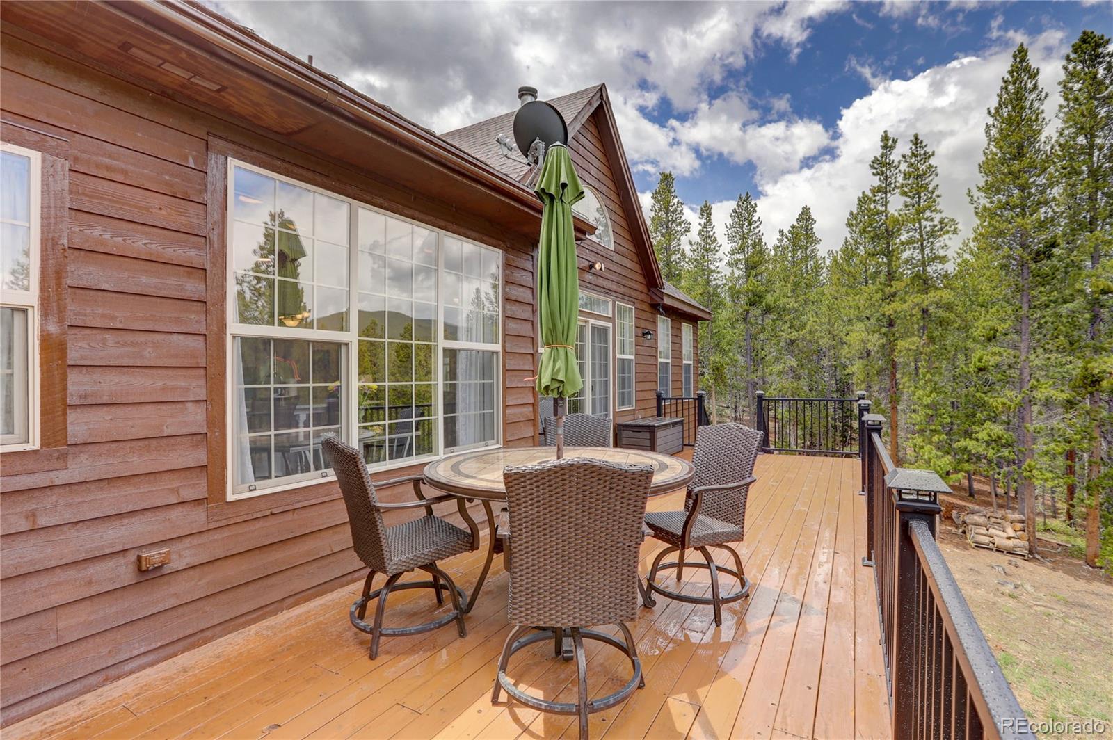 634 Foxtail Circle Black Hawk, CO 80422 - Photo 20 of 40 a view of a patio with table and chairs with wooden floor and fence