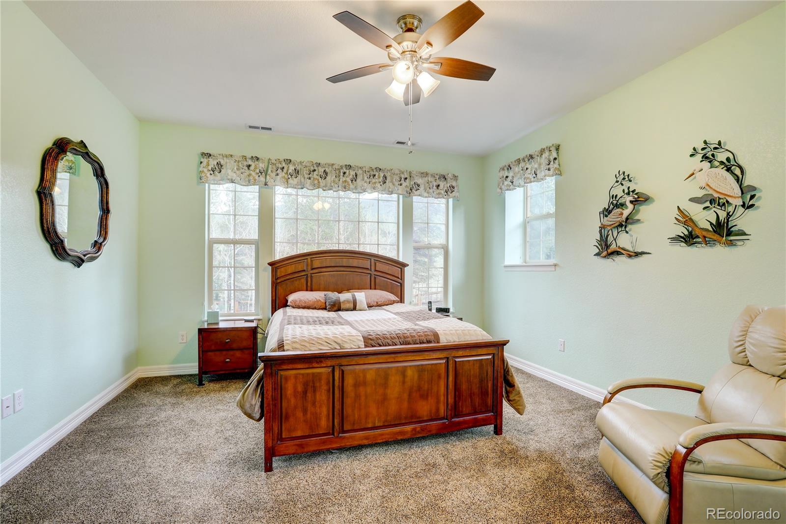 634 Foxtail Circle Black Hawk, CO 80422 - Photo 30 of 40 a bedroom with a bed and a chandelier