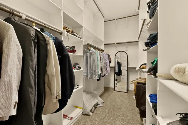 a view of walk in closet with clothes and shoes