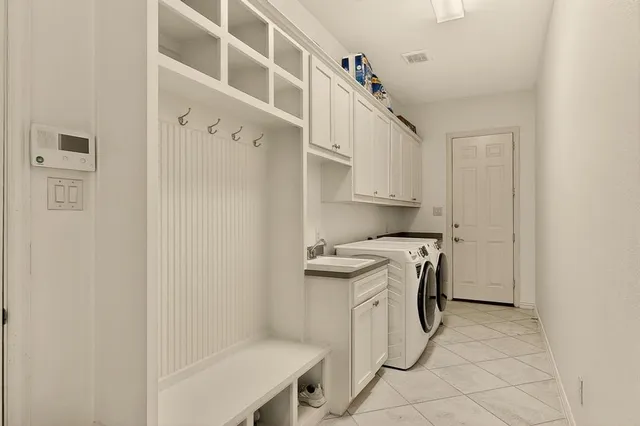 a utility room with cabinets washer and dryer
