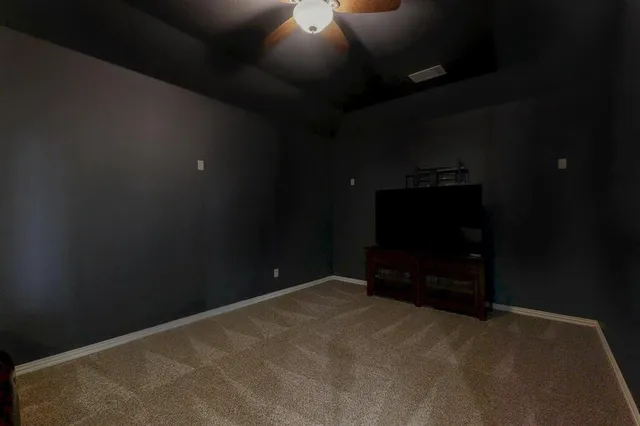 a view of an empty room with a ceiling fan