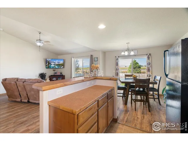 a dining hall with stainless steel appliances kitchen island a table and chairs