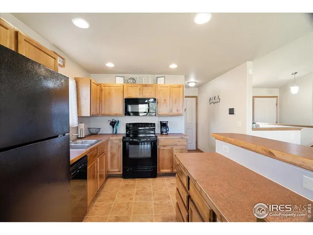 a kitchen with stainless steel appliances kitchen island granite countertop a refrigerator oven a sink and dishwasher