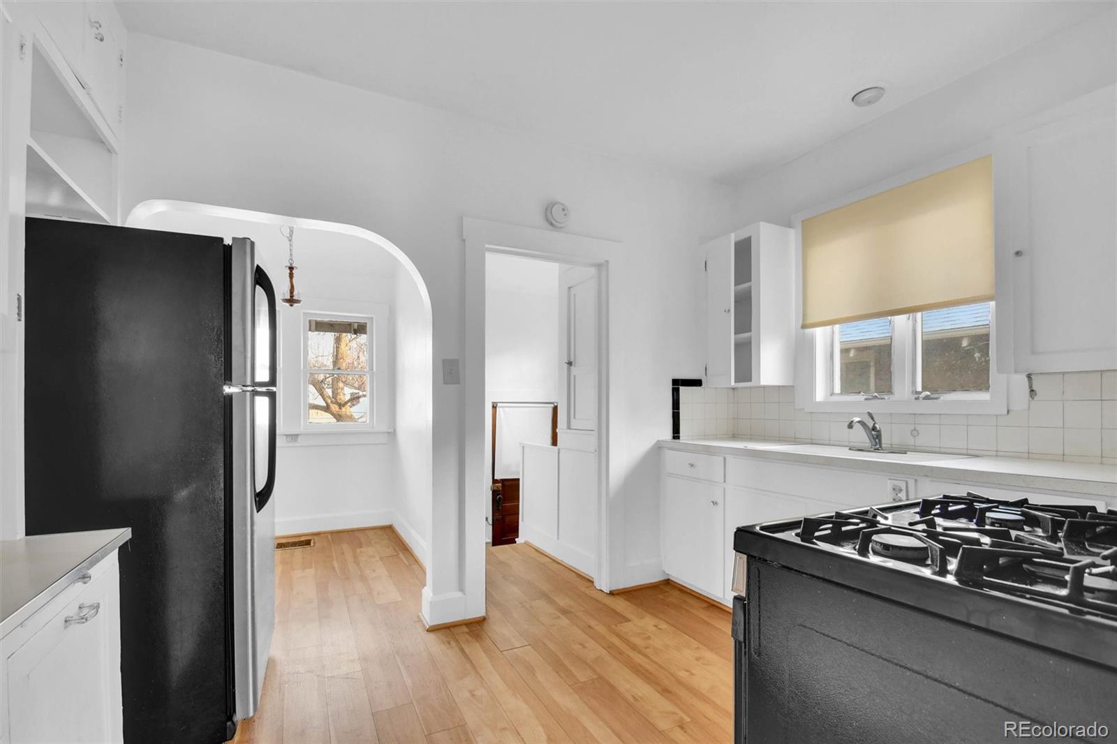 3159 West 36th Avenue Denver, CO 80211 - Photo 11 of 33 a kitchen with stainless steel appliances granite countertop a refrigerator and a stove top oven