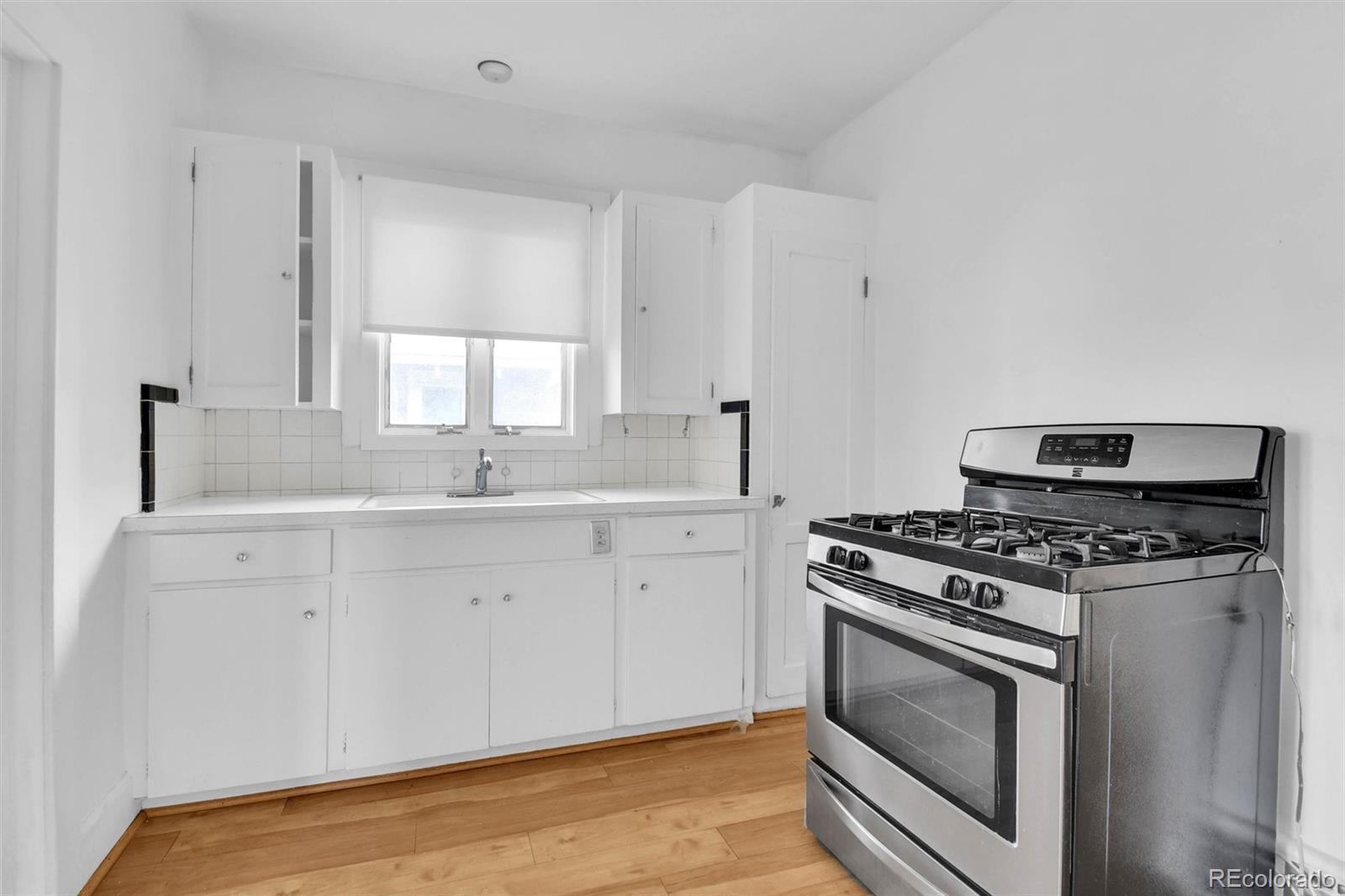 3159 West 36th Avenue Denver, CO 80211 - Photo 12 of 33 a kitchen with a stove and white cabinets