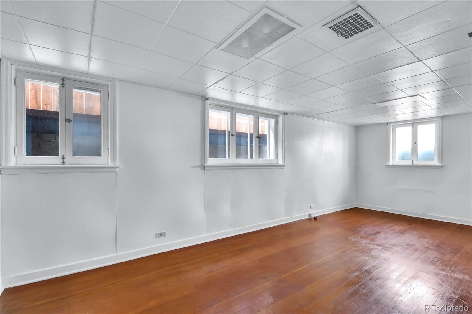 3159 West 36th Avenue Denver, CO 80211 - Photo 25 of 33 an empty room with wooden floor and windows
