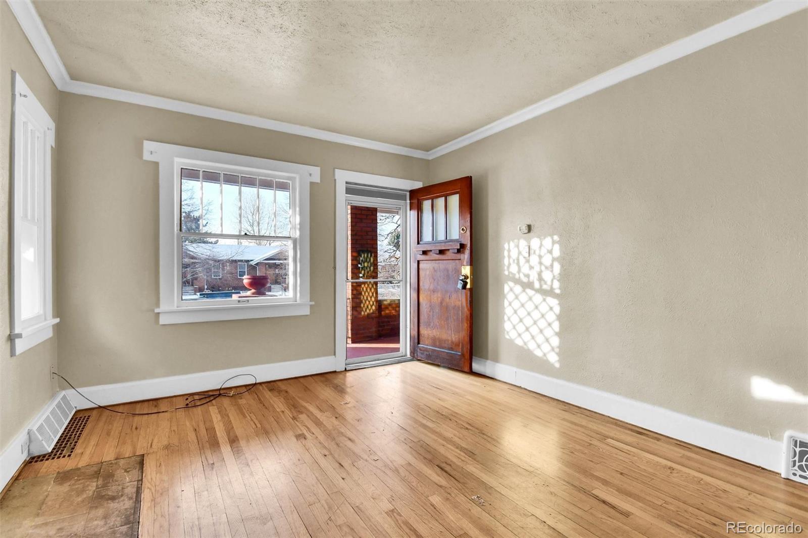 3159 West 36th Avenue Denver, CO 80211 - Photo 7 of 33 a view of an empty room with window and wooden floor