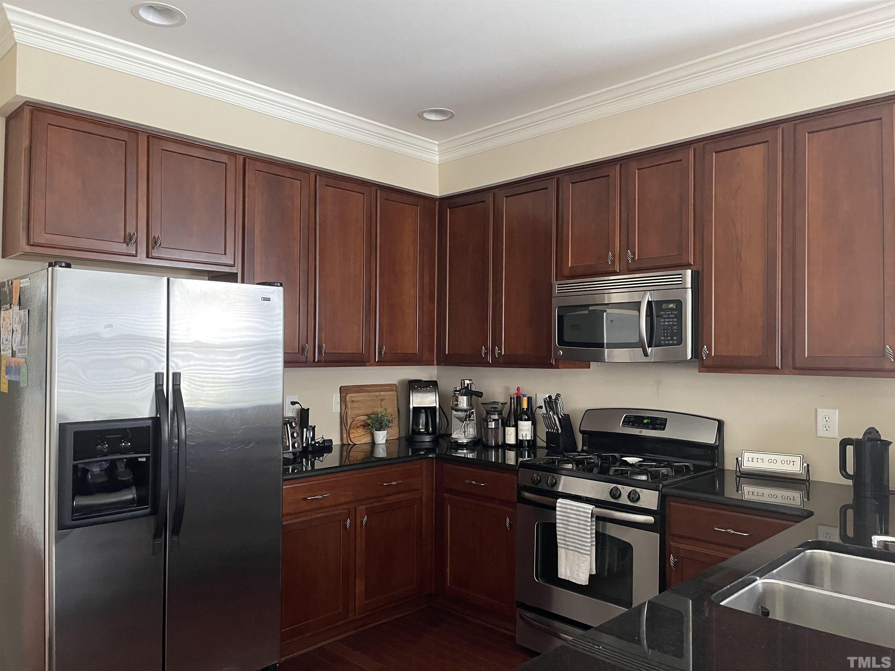 4711 Altha Street Raleigh, NC 27606 - Photo 6 of 25 a kitchen with stainless steel appliances granite countertop a refrigerator stove top oven