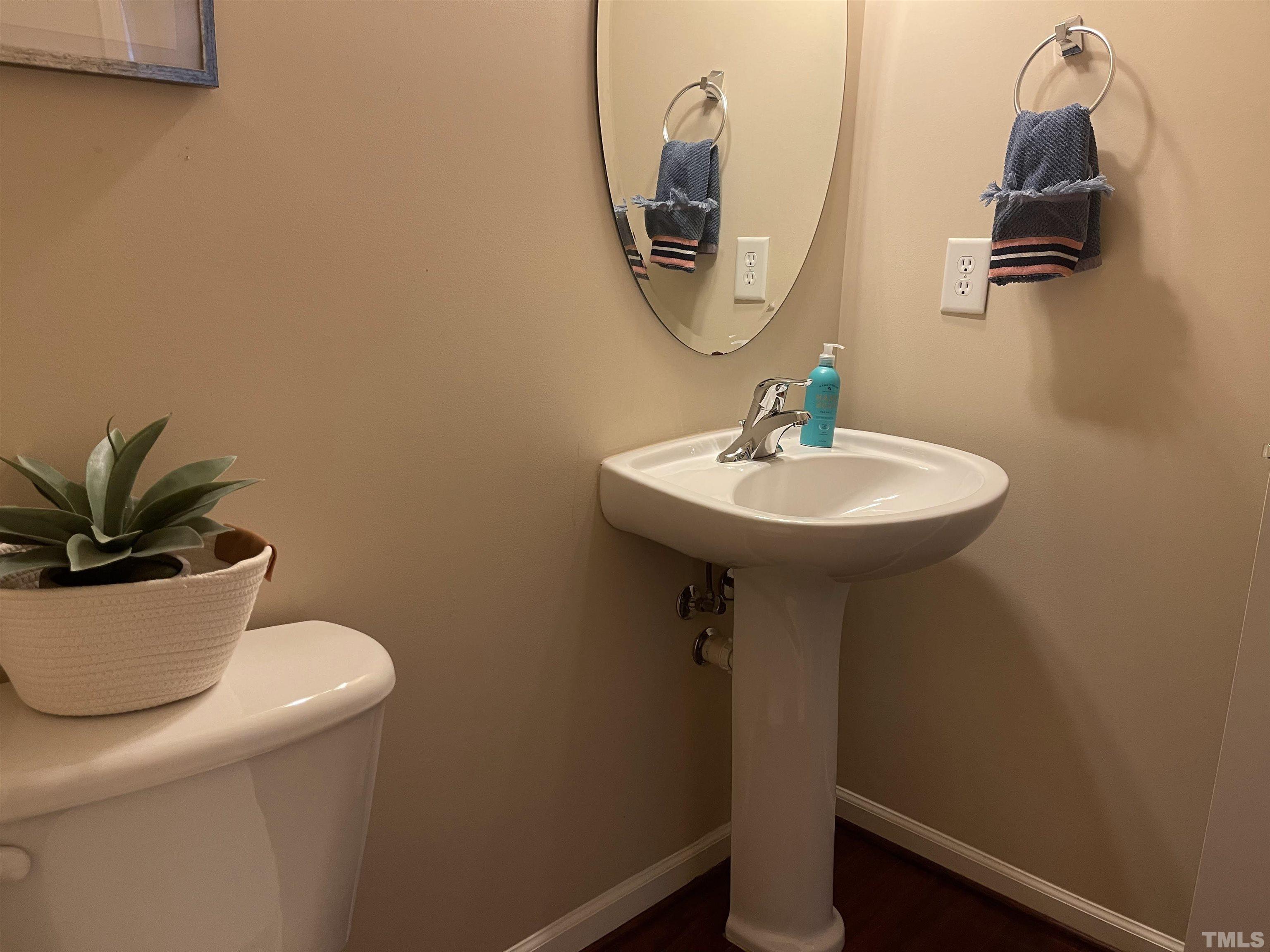 4711 Altha Street Raleigh, NC 27606 - Photo 8 of 25 a bathroom with a sink a toilet and mirror