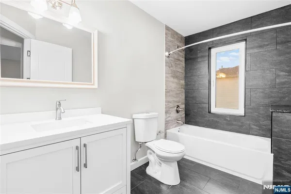 a bathroom with a sink toilet vanity and bathtub