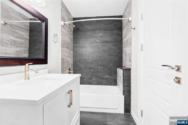 a bathroom with a sink a mirror and a bathtub