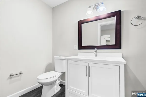 a bathroom with a toilet sink vanity and mirror
