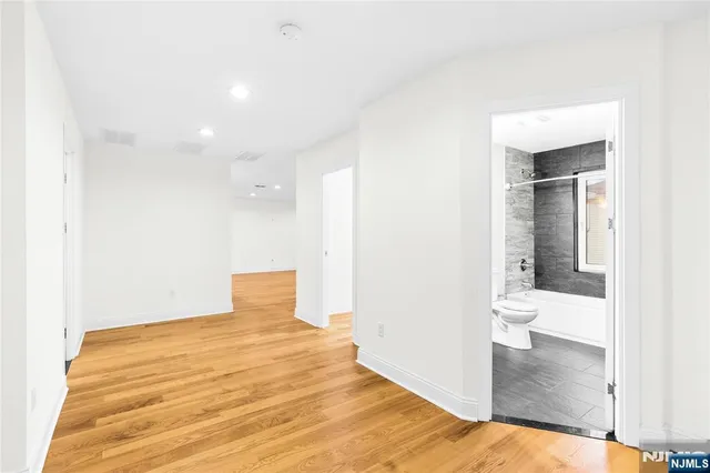 a view of a room with wooden floor and a bathroom