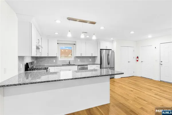 a large kitchen with granite countertop a large counter top stainless steel appliances and cabinets